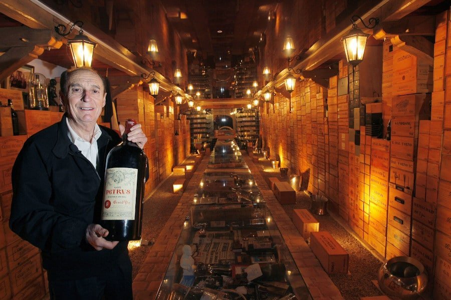The ‘Louvre of Wine’ Museum - Gastronomy Tours man smiling at the camera and holding a big bottle of champagne at The ‘Louvre of Wine’ Museum