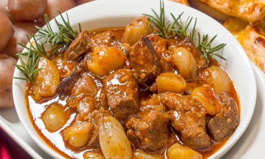 Why stifado is ‘the best food in Greece’ – plus the recipe - Gastronomy Tours plate with ‘stifado’ means cooking meat with onions in tomato sauce and is the best food in Greece|