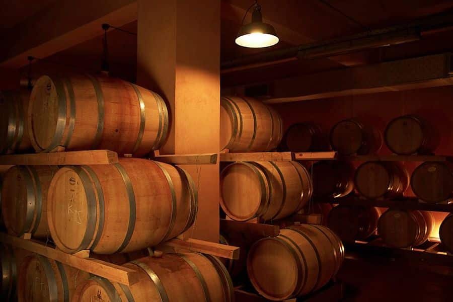 Contact Us - Gastronomy Tours wine wood barrels on top of each other at Boutari Crete Winery cellar