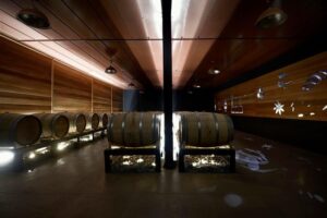 wooden barrels at illuminated Callicounis Distilleries cellar