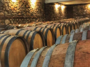 wooden wine barrels on the ground in stone Chateau Kaniaris winery cellar