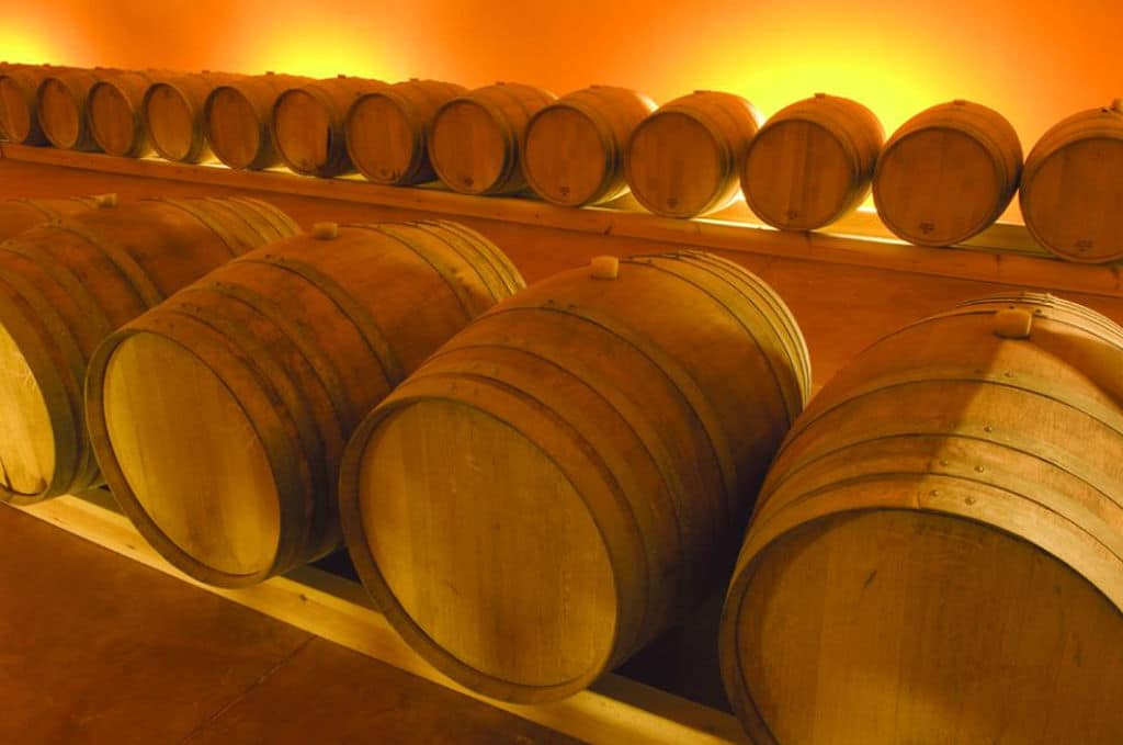 Domaine Zacharioudakis Awards - Gastronomy Tours lying wooden barrels in a row at ‘Domaine Zacharioudakis’ cellar that recognized with many awards|