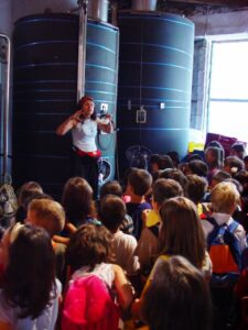 A group of children listening to a woman giving a tour at Georgas Family winery facilities