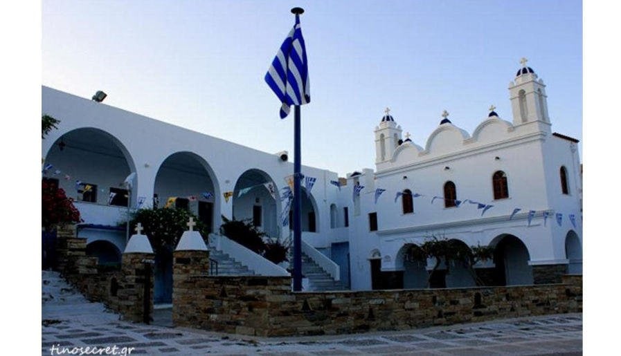 Tinos, Hora, Festival of Agia Varvara - Gastronomy Tours Hora with a Greek flag outside