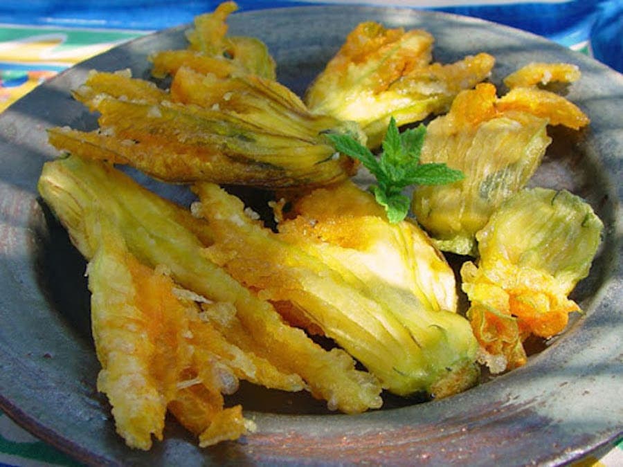 Kolokithokorfades - Gastronomy Tours close-up of plate with ‘Kolokithokorfades’ means fried zucchini blossoms
