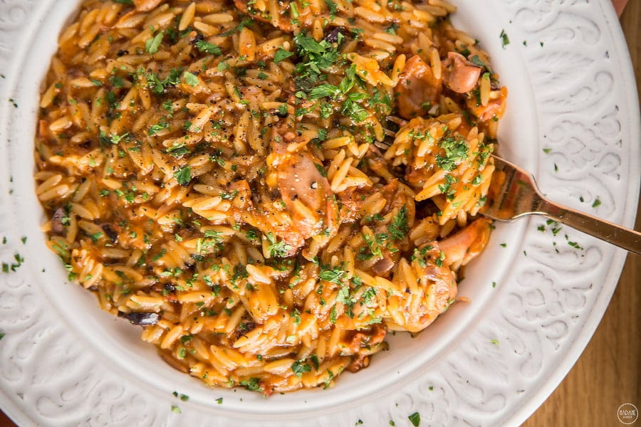 Kritharaki: Greece’s Tiny Pasta with Big Flavour - Gastronomy Tours Close-up of Greek ‘Kritharaki’ food means orzo pasta cooked with tomatoes sauce and peces of meat
