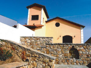 stone wall in the background of top of the Lafkiotis Winery building