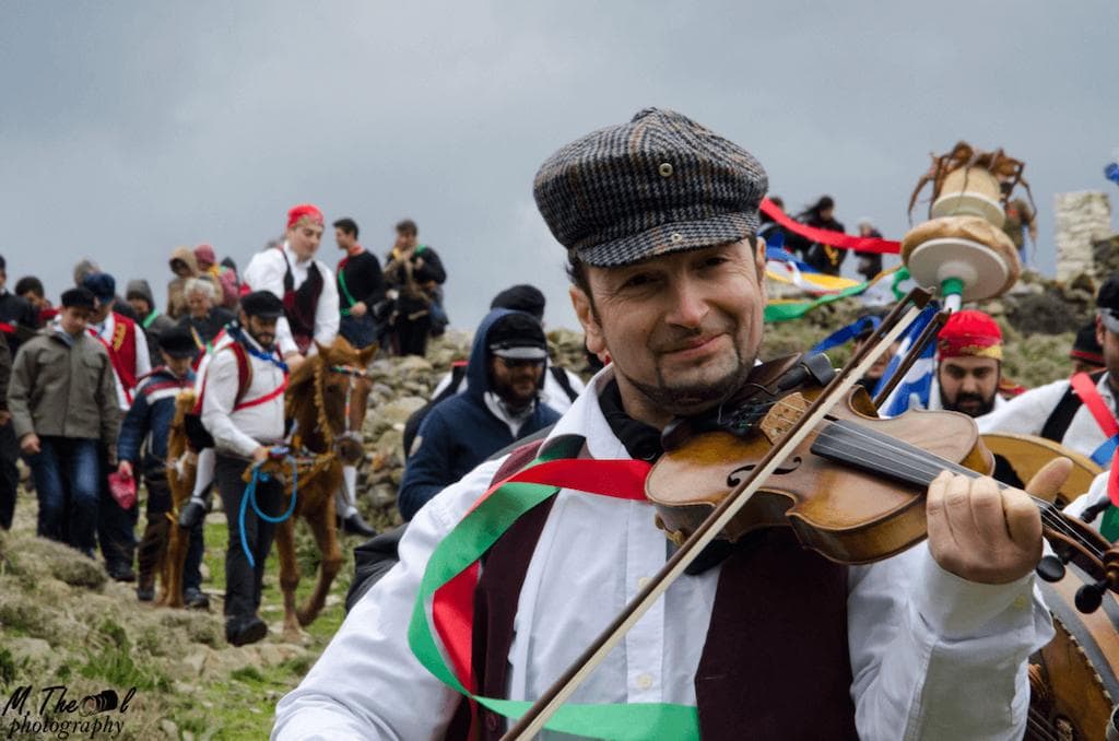 Amorgos, the Captain's Custom - Gastronomy Tours a man smiling and play violin