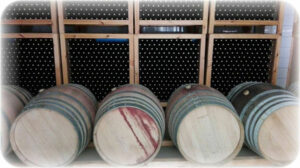 lying wood barrels front the stacked bottles on top of each other in the storage locker at 'Anoskeli'