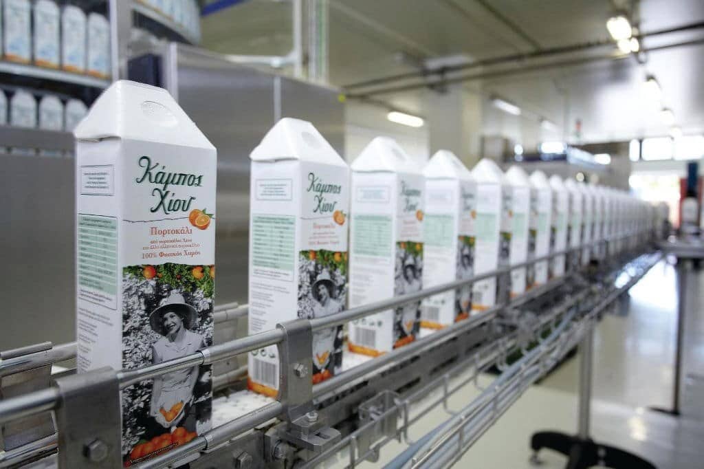 Chios Fruits Awards - Gastronomy Tours Conveyor belt or line with juice bottles on beverage factory equipment machinery at ‘Chios Fruits’ that recognized with many awards|