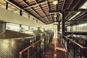 a corridor between aluminum wine storage tanks on the top of these at Domaine Papagiannakos plant