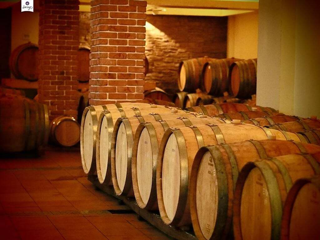 Dougos Winery Awards - Gastronomy Tours wooden barrels on top of each other at ‘Dougos Winery’ cellar that recognized with many awards|