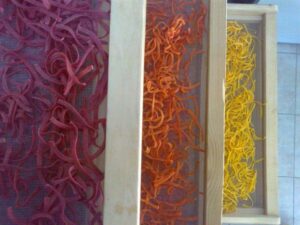 wood frames with multicolor hilopites pasta on top of each other at Thracian Pasta