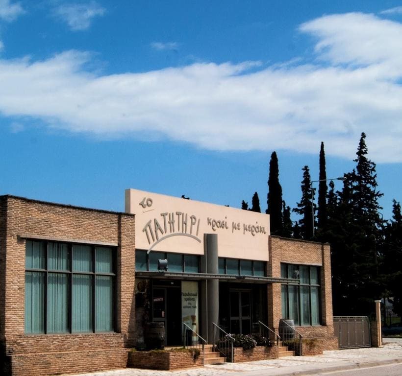 Papagiannis Winery - To Patitiri Awards - Gastronomy Tours front view of the Papagiannis Winery building that said in Greek to patitiri|logo of Papagiannis winery vineyards