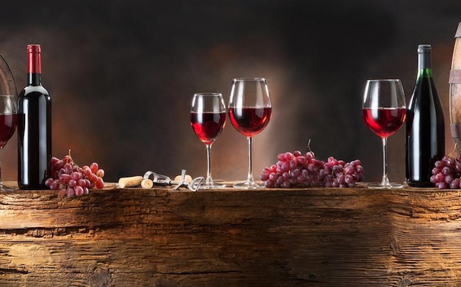 Naoussa, City of Wine - Gastronomy Tours glasses with red wine and grapes and bottles on the table