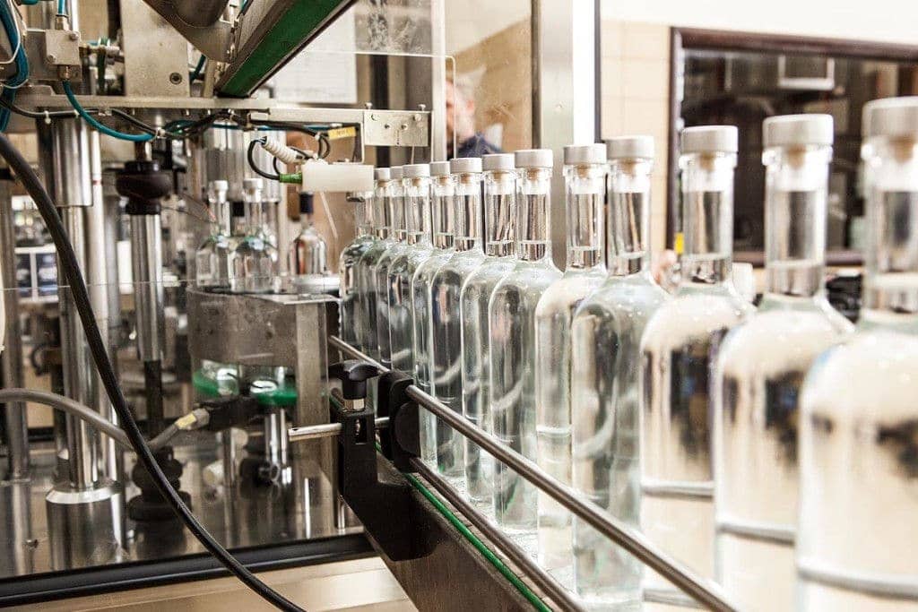 Katsaros Distillery Awards - Gastronomy Tours close-up of liquid-filled machine with bottles at ‘Katsaros Distillery’ plant that recognized with many awards|
