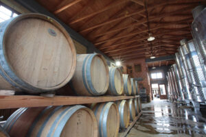 wine wood barrels on top of each other at 'Lefkaditiki Gi' cellar