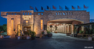 front view of the illuminated building that says 'LYKOSWINERY' in upper part of the wall by night