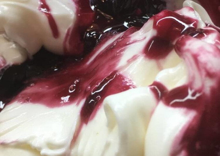 Kaimaki - Gastronomy Tours close-up of Greek ‘Kaimaki’ ice cream like vanilla ice cream with heights syrup on top