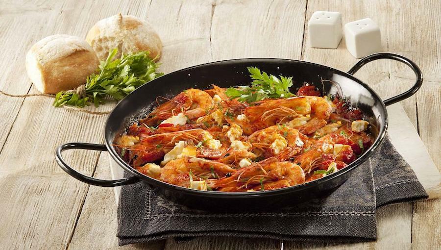 Saganaki - Gastronomy Tours Cooked Greek Saganaki means fried shrimps with white cheese in a small pan with two handles