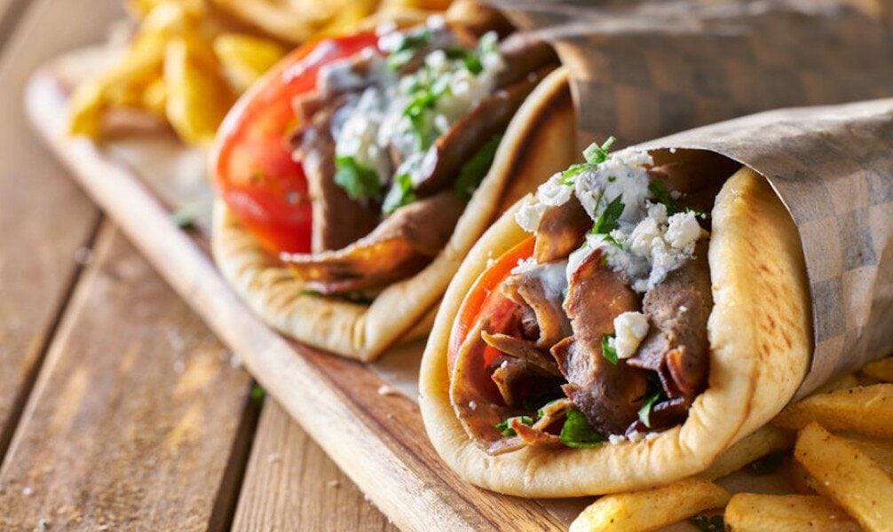 Souvlaki - Gastronomy Tours Greek ‘souvlaki’ with pitta bread, grilled chunks of meat with ‘tzatziki’ yogurt, fried potatoes and piece of tomato