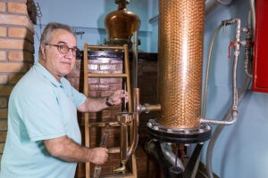 man taking sample alcohol from distillery equipment spirits at 'Spentza Distillery'