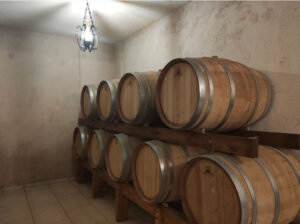 wine wood barrels on top of each other at illuminated 'Stilianou Winery' cellar