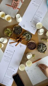 view from above of a table with bowls with dried herbs, plastic glasses, instruction sheets for the tasting at Rhoeco Fine Organic Goods
