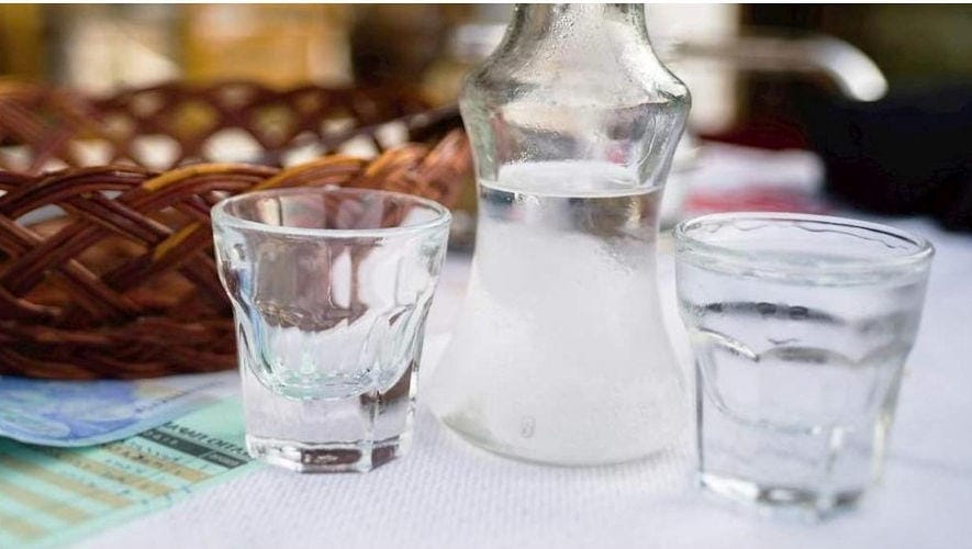 Tsipouro - Gastronomy Tours Close-up of bottle and glasses with Greek ‘Tsipouro’ is produced by distilling the grape