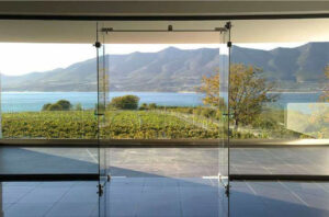 view from glass doors of 'Voyatzis Estate' with vineyards, mountains and the sea