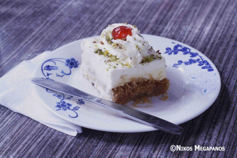 Ekmek kataifi - Gastronomy Tours Close-up of plate with Greek ‘Ekmek kataifi’ means pan-baked sweet covered with syrup and whipped cream on top