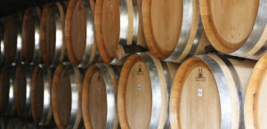 close-up of wine wood barrels on top of each other at Ktima Spiropoulos cellar